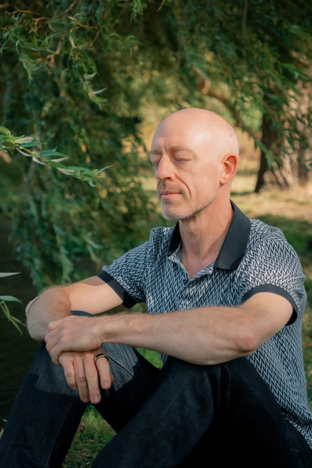 John sitting quietly beneath a willow tree